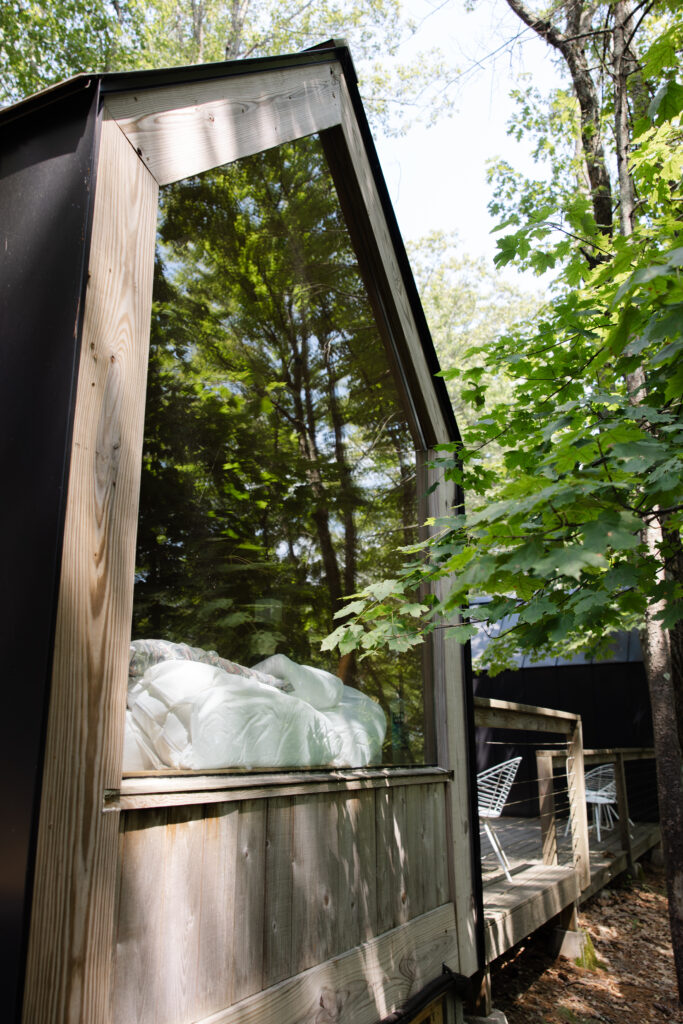 Gather Greene cabin suite at an Upstate New York wedding venue, featuring modern wood architecture and forest views through floor-to-ceiling glass.