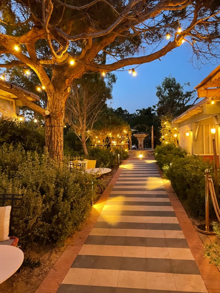 Evening walkway at Hotel Lillien, an Upstate New York wedding venue illuminated by string lights and surrounded by garden greenery.
