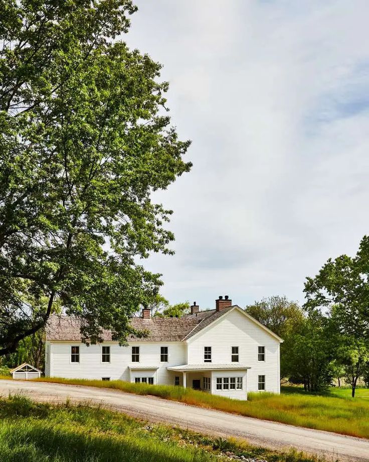 White farmhouse at Inness, an Upstate New York wedding venue blending pastoral charm with contemporary design and sweeping countryside views.