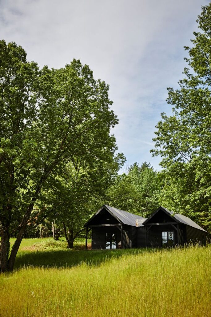 Cabins at Inness, a Hudson Valley wedding venue surrounded by tall grass and trees, offering private accommodations for destination weddings.