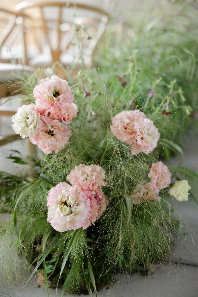 Soft pink flowers with greenery backdrop