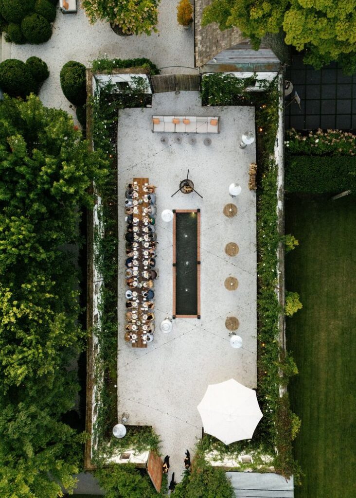 Aerial view of Valley Rock Inn & Mountain Club wedding reception courtyard in the Hudson Valley, featuring long dining tables and garden pathways.