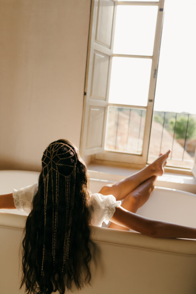 Bride in a beaded headpiece resting by a sunlit window at Vestige Son Vell, Menorca