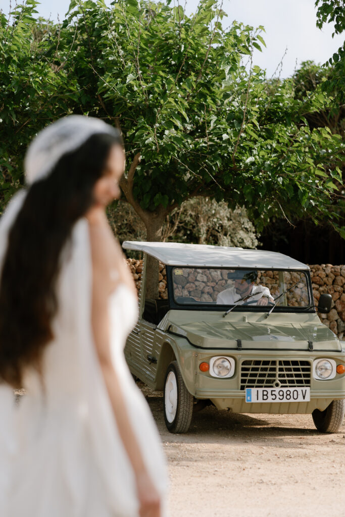 Bride beside a vintage green Land Rover on an estate lane at Son Vell, Menorca