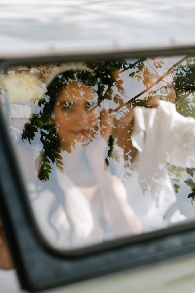 Bride and groom seen through the windscreen of a vintage car, Menorca
