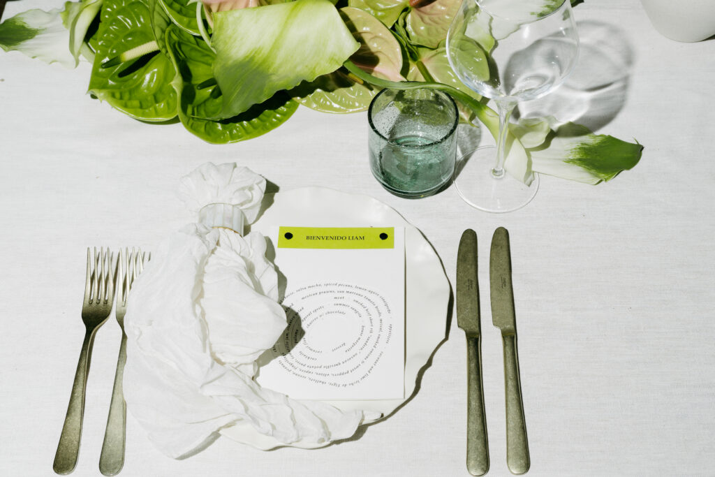 Welcome dinner place setting with green anthurium and a spiral printed menu