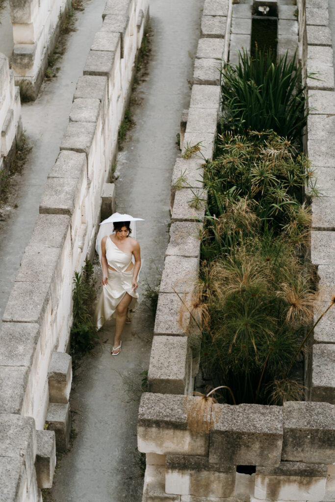 Bride and groom in close silhouette against the carved limestone walls and sky of Lithica Quarry, Menorca.