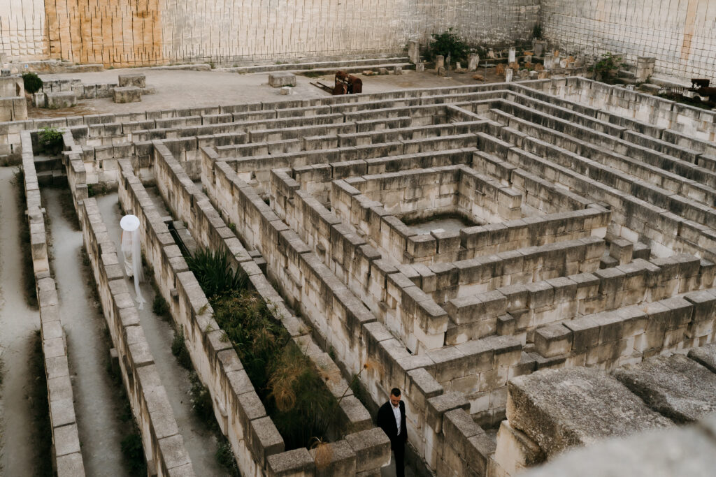 The stone labyrinth of Lithica Quarry from above, a single figure walking the maze — the Labyrinth Quarry, Menorca.