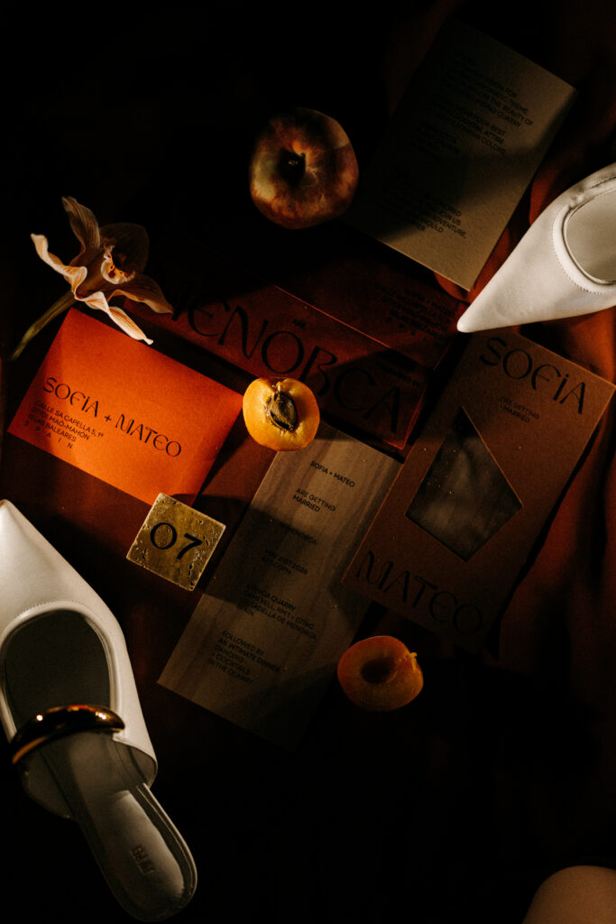 Terracotta wedding stationery suite styled with apricots and bridal shoes, escort card detail, Lithica Quarry, Menorca 