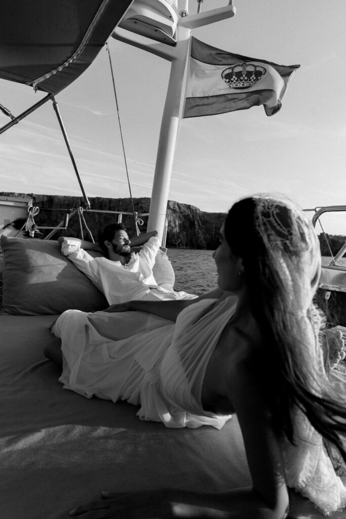 Bride and groom reclining aboard a boat off the Menorca coast, black and white