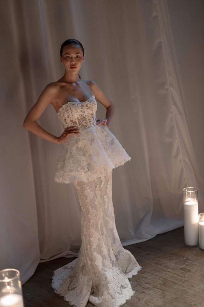Model wearing the Greta gown by Naeem Khan, a strapless embroidered column dress with train and sculptural lace patterning.