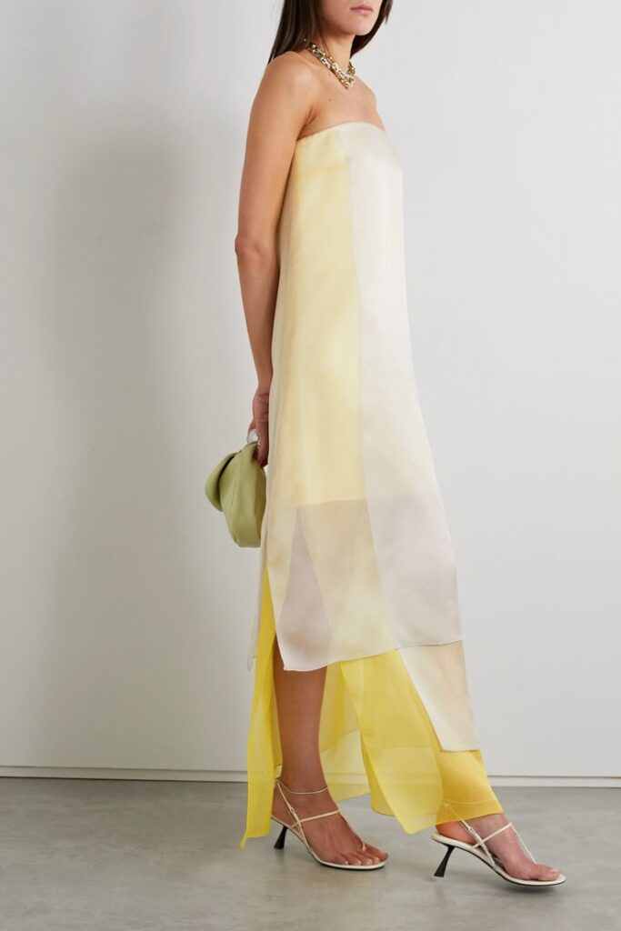 A floaty strapless slip dress in sheer yellow and ivory panels, layered with asymmetrical cuts and paired with strappy heels. Whimsical and modern with a whisper of sunshine.