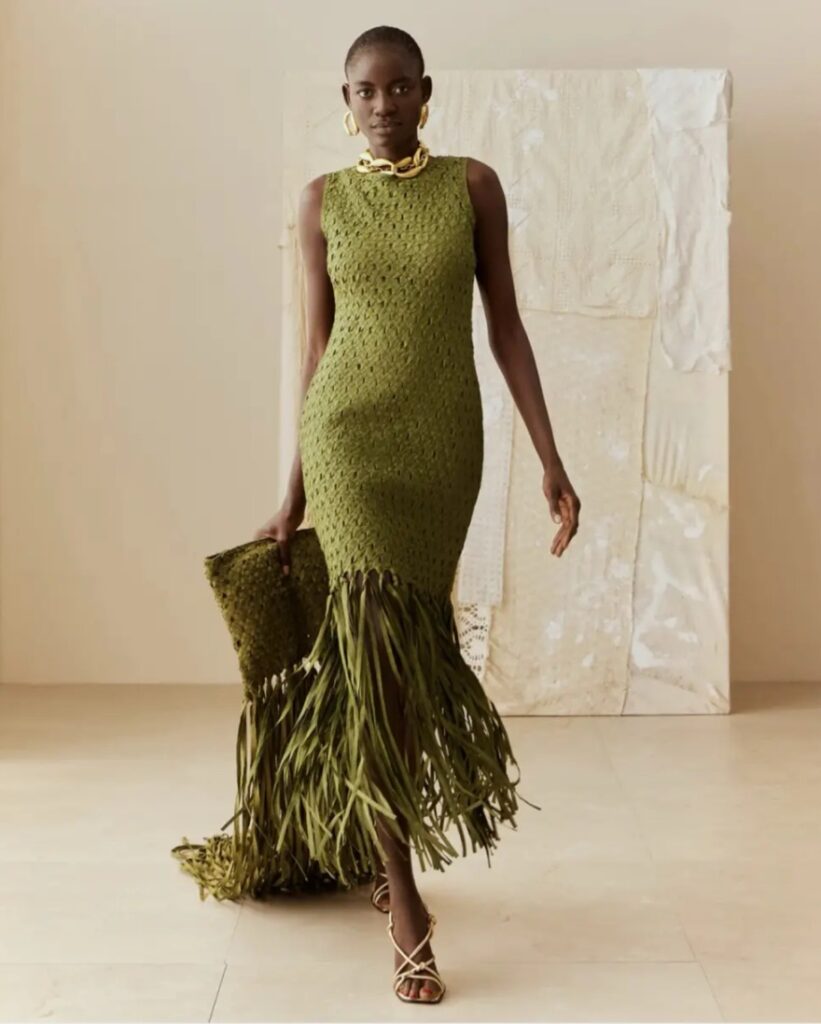 Wedding guest in an olive green crochet dress with fringe hem and gold accessories — textural, natural-toned outfit for an earthy and elevated wedding style.